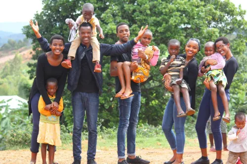 A vibrant and joyful group of family members celebrating together outdoors in Gitega, Burundi.