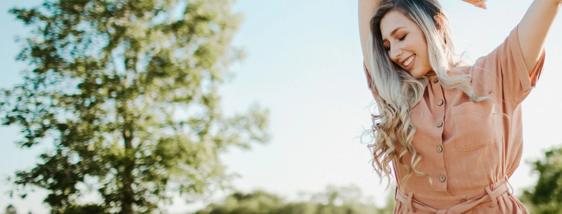 A cheerful woman enjoying a sunny day outdoors in Dayton, Ohio.