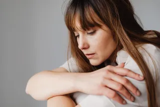 A woman sits with a serene expression, lost in deep thought.