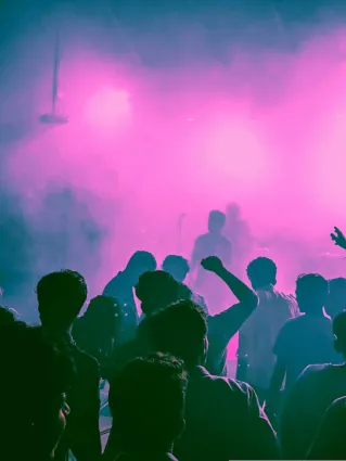 Vibrant nightlife scene with a crowd enjoying live music and bright stage lights.