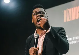 Confident man speaking passionately at an indoor event. Perfect for business and motivational themes.
