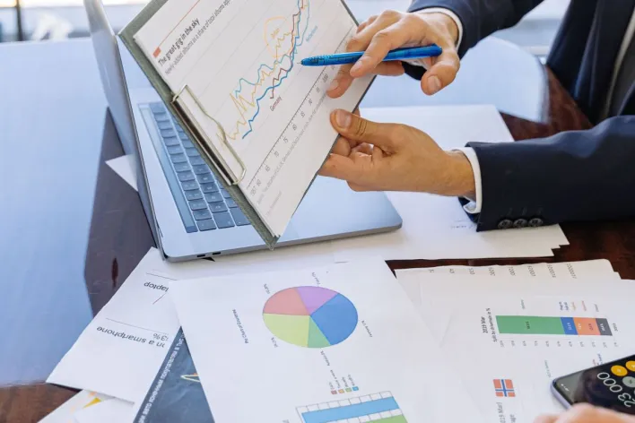 Business professionals discussing financial graphs and charts in an office setting.