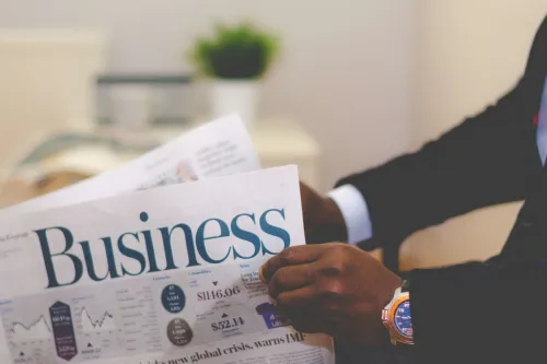 A business professional reading a newspaper, representing how people, processes, and privacy shape the business.