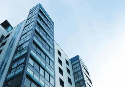 Low-angle view of a modern glass skyscraper against a clear sky in Poole, UK.