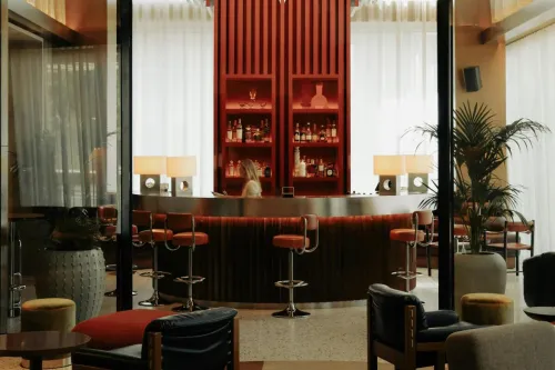 Vintage-style hotel lobby in Brussels with bar area and modern furniture.