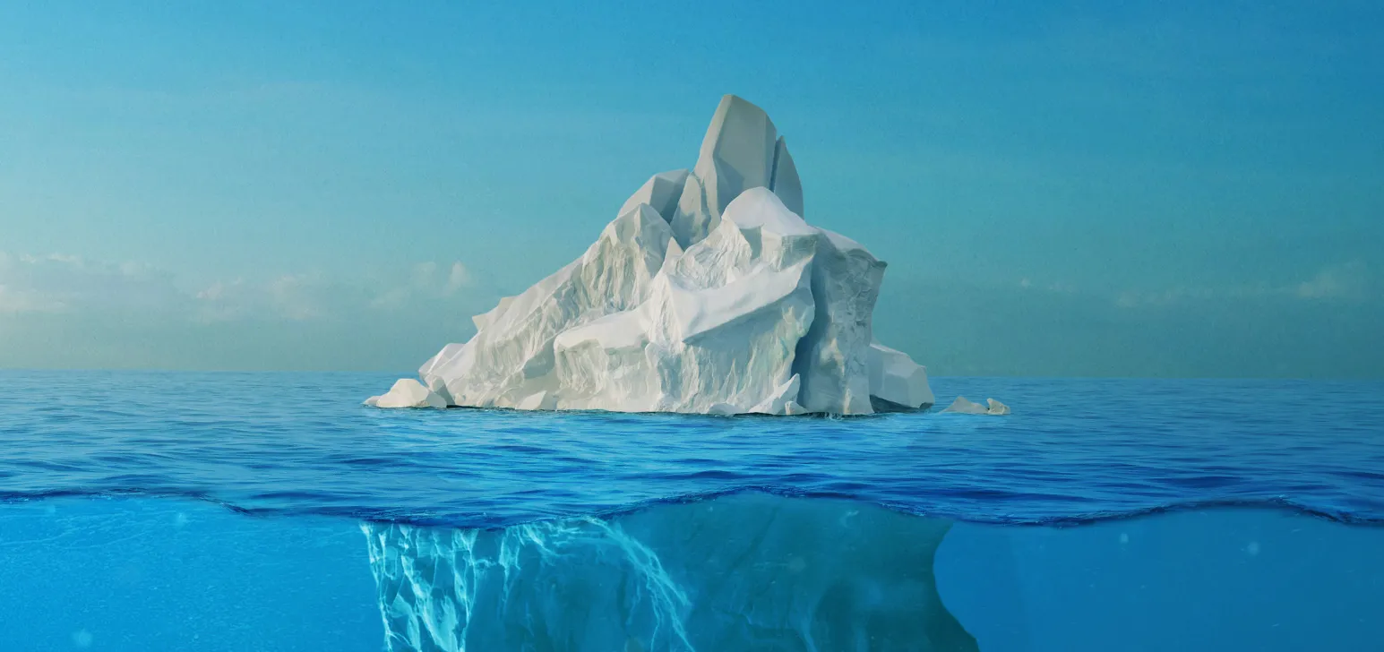 Stunning aerial shot capturing a large iceberg floating in turquoise waters.