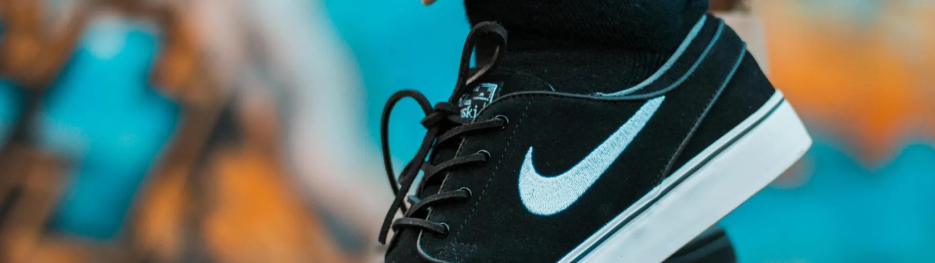 Close-up of black sneakers with camouflage pants, showcasing urban style.