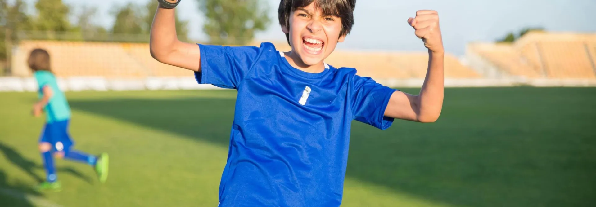 Joyful boy celebrating a soccer win outdoors in Portugal.