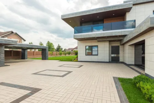 Contemporary residence with sleek design, large driveway, and landscaped yard.