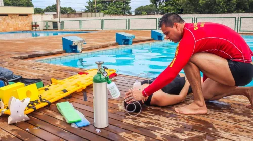 Lifeguard providing emergency care to a swimmer by a swimming pool in Mato Grosso, Brazil.