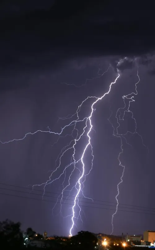 Powerful lightning strike illuminates the night over a South African landscape, showcasing nature's fierce beauty.