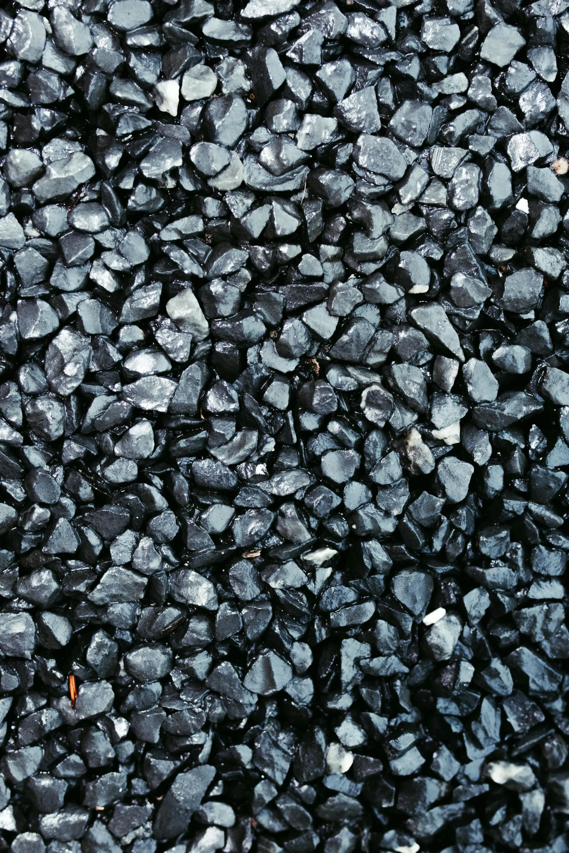 Detailed close-up image of a textured black gravel surface, ideal for backgrounds.