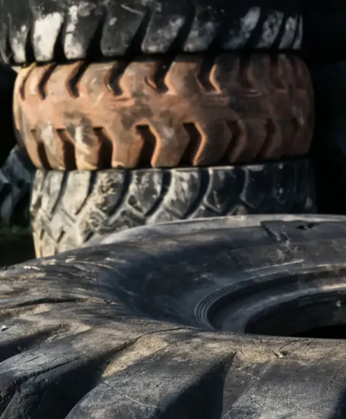 Black and white image of stacked vehicle tires showcasing various tread patterns.