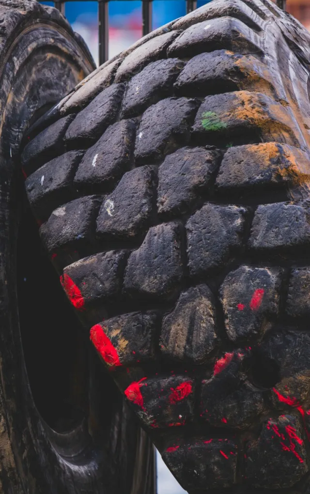Detailed shot of a sleek car wheel and rim on a black vehicle, showcasing automotive design.