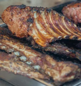 Close-up of delicious grilled ribs fresh from the BBQ grill, perfect for a summer feast.