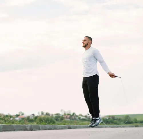 Man performing jump rope exercise outdoors for fitness and healthy lifestyle.