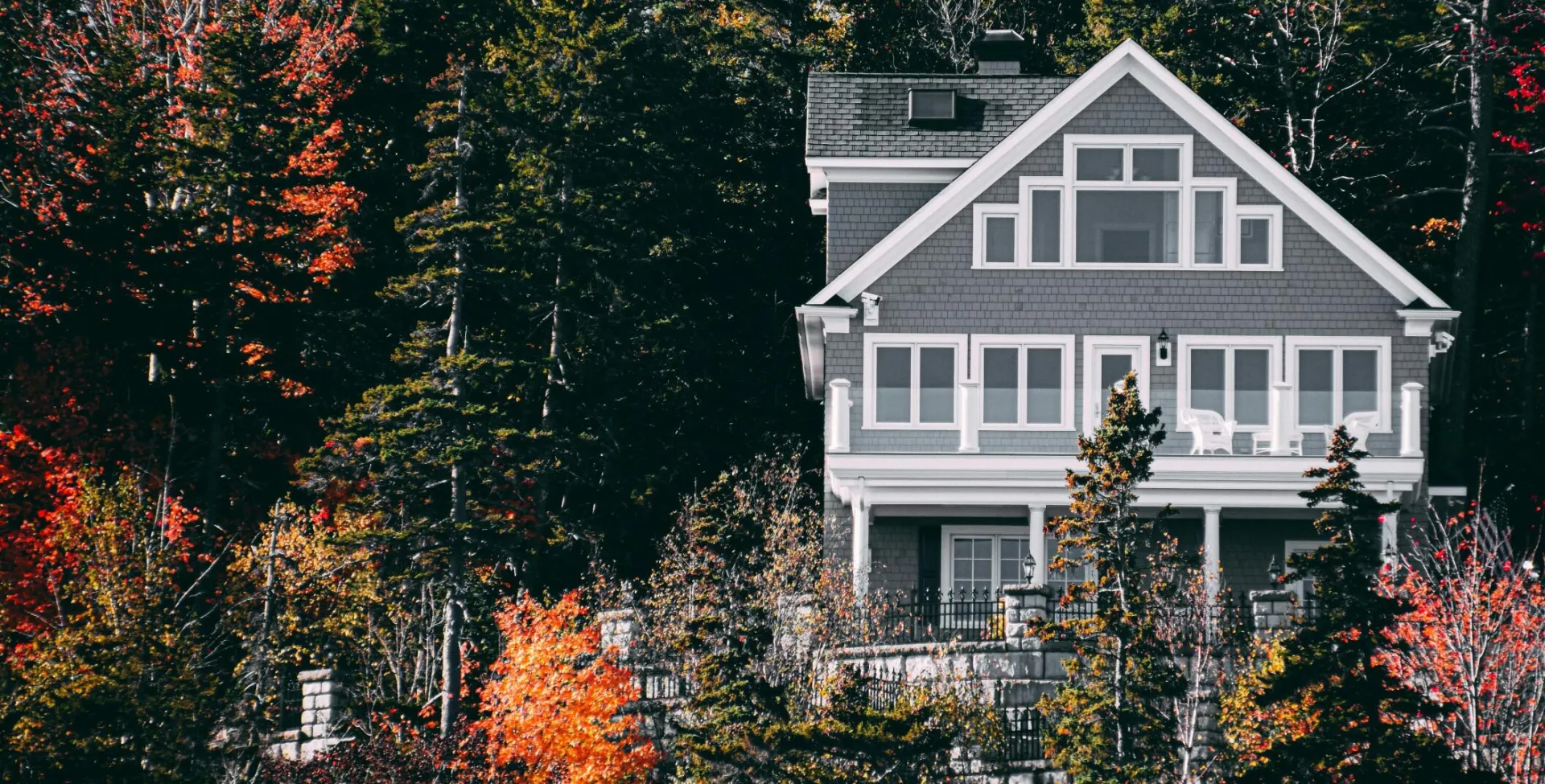 Elegant family home set against a vibrant autumn forest backdrop.