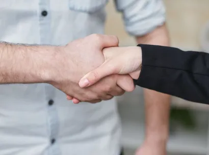 Close-up of two individuals shaking hands symbolizing business agreement and partnership.