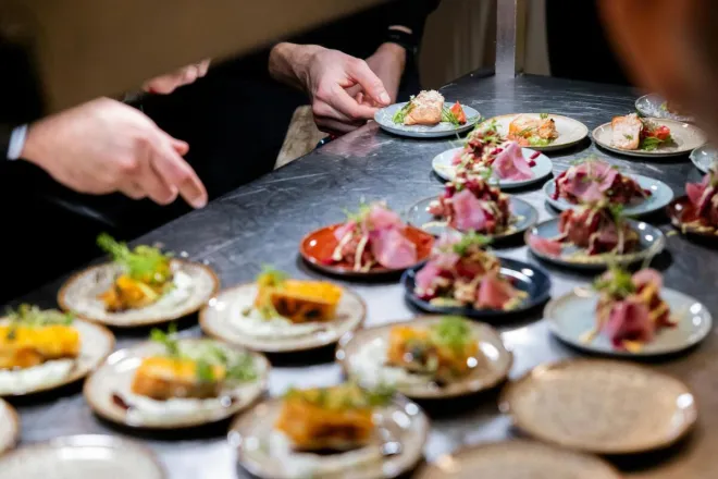 Chefs expertly plate gourmet dishes at a culinary event in Hamburg, showcasing vibrant colors and textures.