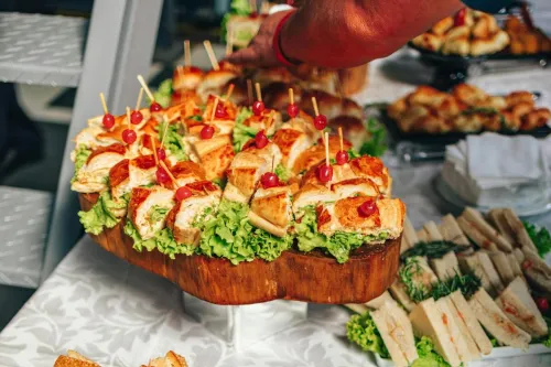 Close-up of a vibrant sandwich buffet with fresh lettuce and garnish on a tablecloth.