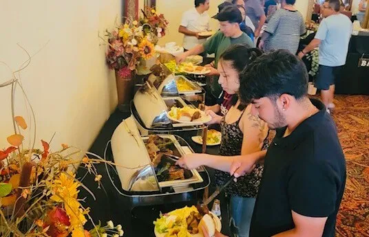Gourmet appetizers at a stylish indoor event with attendees in formal attire.