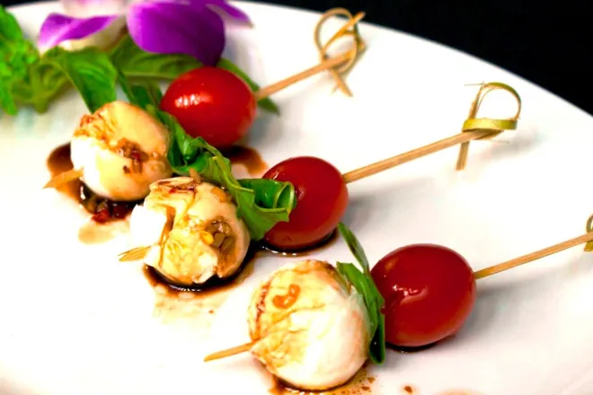 Beautiful arrangement of desserts and flowers on a table outdoors, perfect for events and celebrations.