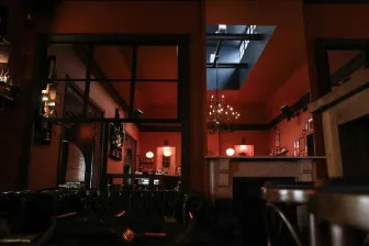 A warm, rustic bar interior with elegant lighting and vintage decor, perfect for social gatherings.