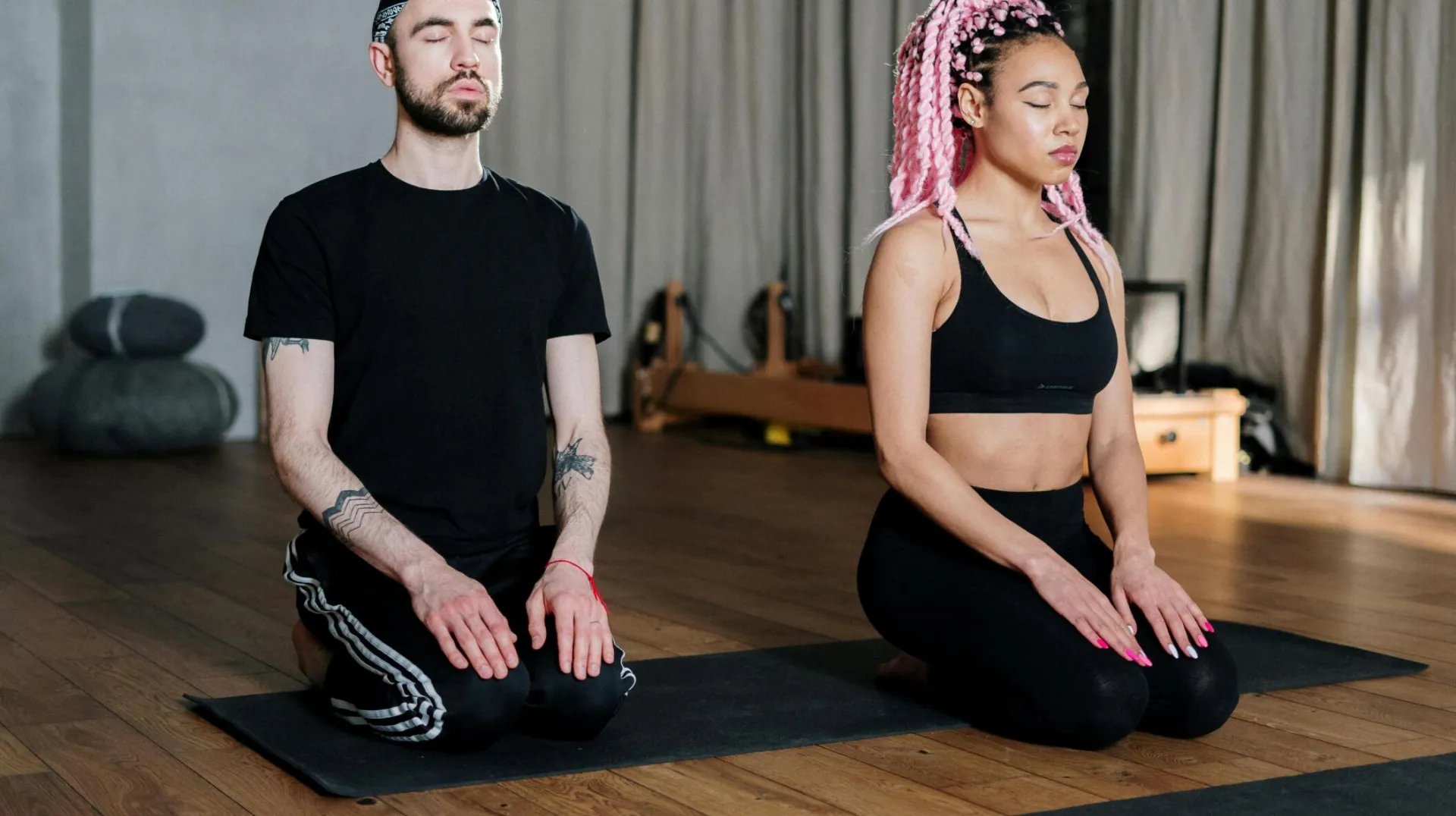 Focused duo practicing meditation in a peaceful yoga studio environment for wellness.