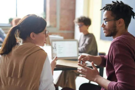 A diverse group of professionals engaged in a collaborative meeting in a modern office setting.