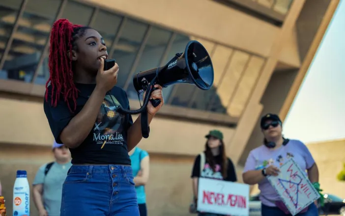 African American woman speaks passionately at a peaceful protest for social activism and women's empowerment.