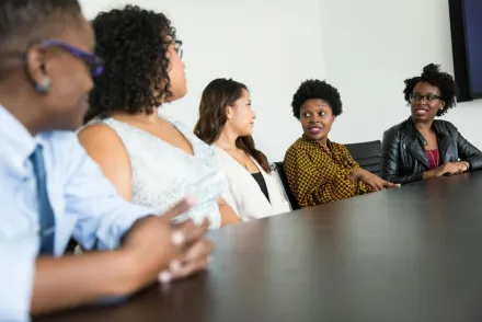 A diverse group of professionals engaged in a collaborative office meeting.
