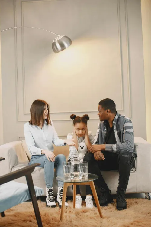 A family engaging in a thoughtful conversation while sitting on a stylish sofa in a modern living room.