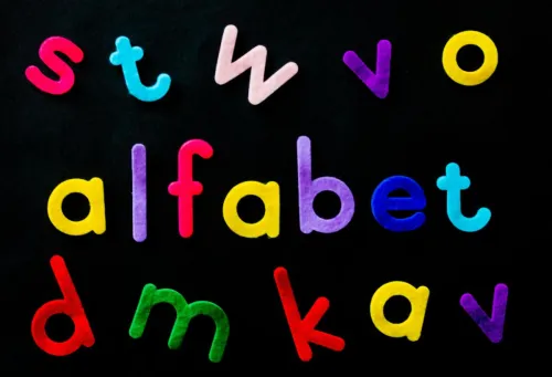Vividly colored alphabet letters arranged on a black backdrop, perfect for educational themes.