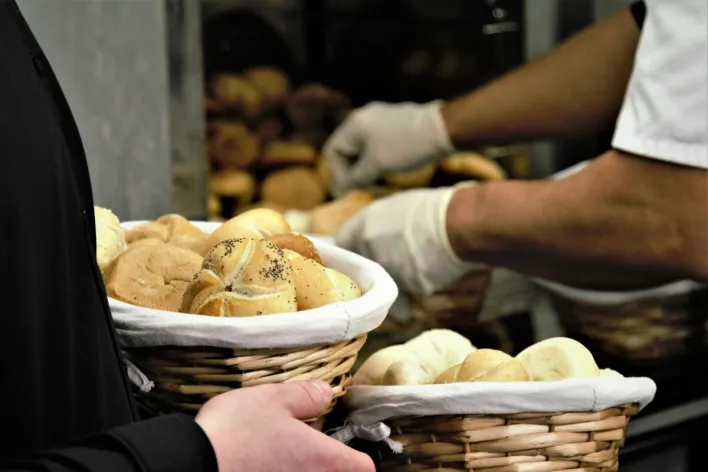 Close-up of fresh bread in woven baskets at a bakery. Perfect for food and business themes.