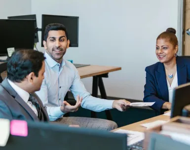 Colleagues engaging in a productive discussion in a modern office setting.