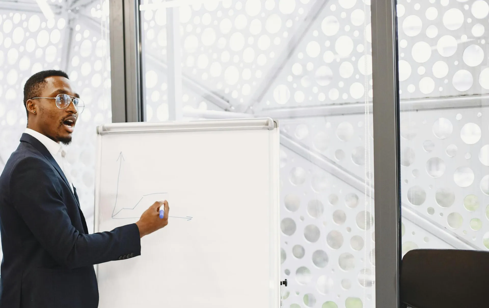 Businessman presenting on a flip chart in a contemporary office setting.