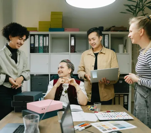 Colleagues engage in a lively discussion during a team meeting in a modern office setting.