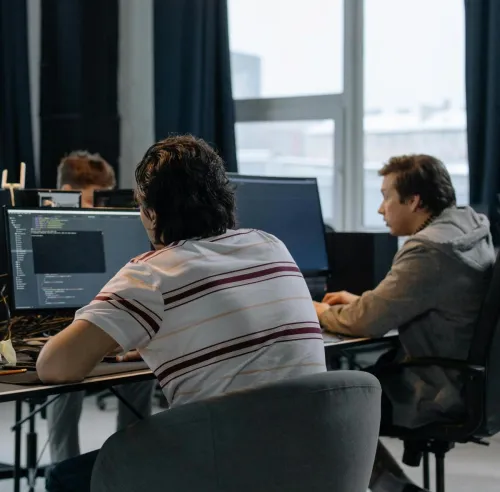 Team of developers working together on computers in a modern tech office.