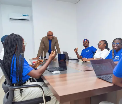 A diverse group of adults collaborating during a business meeting in a modern office setting.