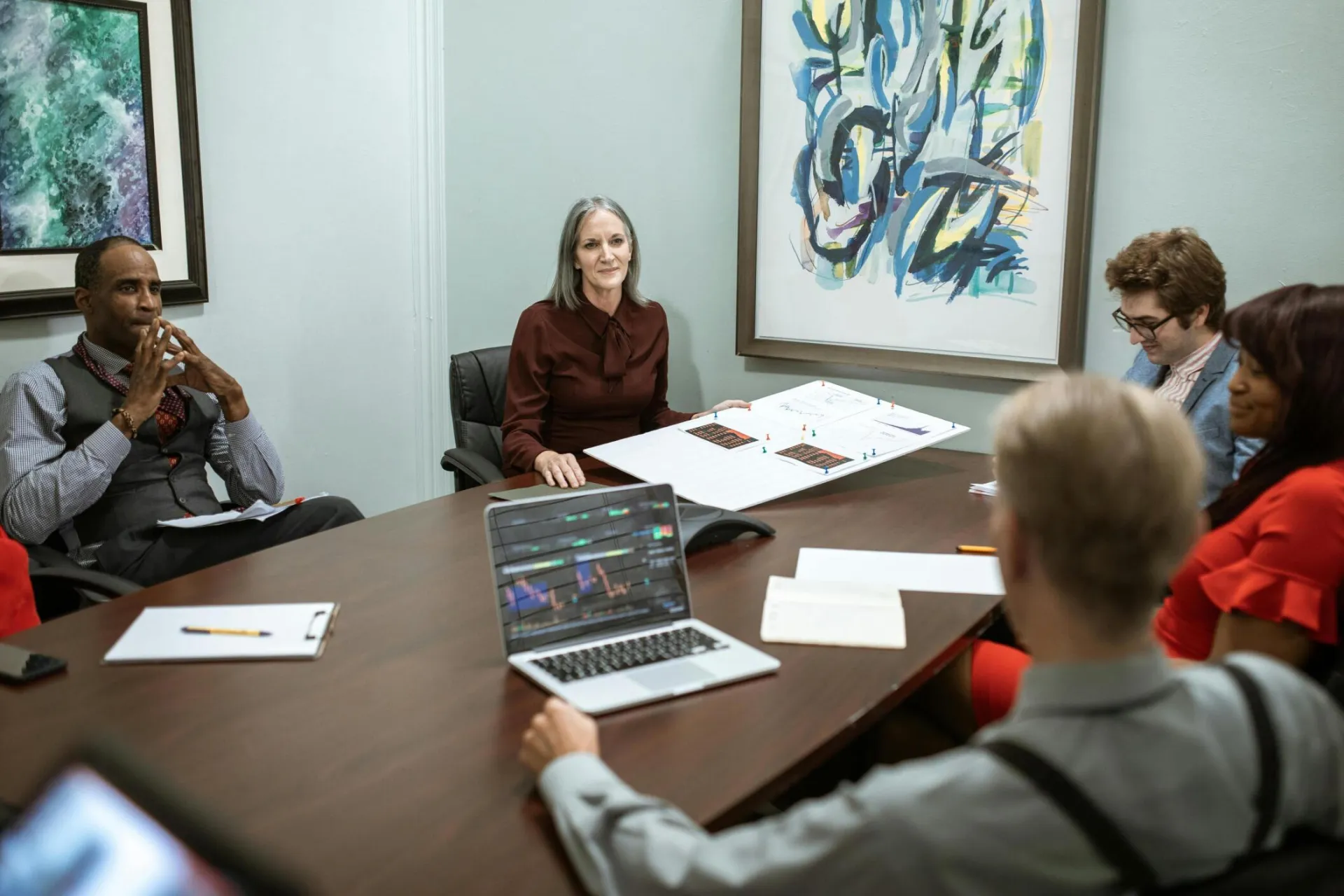 A group of professionals engaged in a business meeting around a conference table.