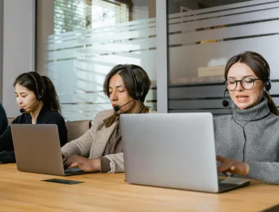 Four customer support agents working diligently in an office setting.
