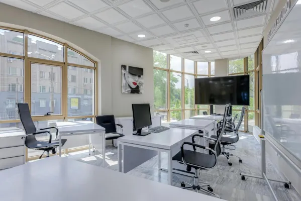 Contemporary minimalist office with glass windows and ergonomic chairs.