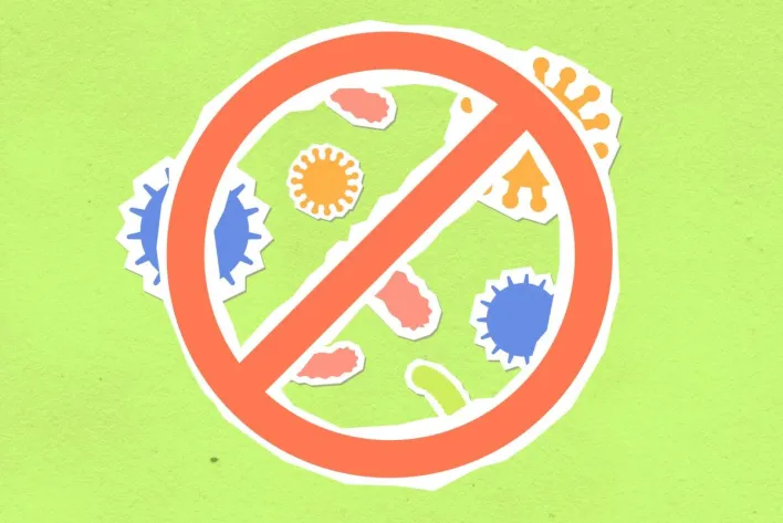 Overhead view of cutout paper composition representing forbidding symbol and different bacteria on green background