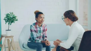 Teenager and therapist in a calm counseling environment.