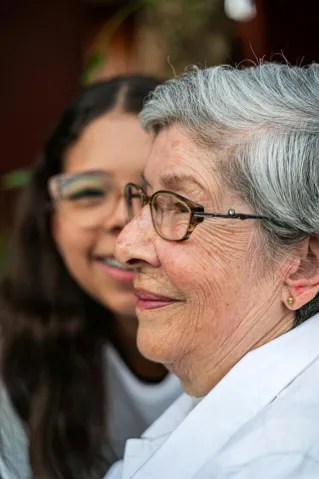 A touching moment between an elderly woman and her granddaughter, showcasing warmth and love.