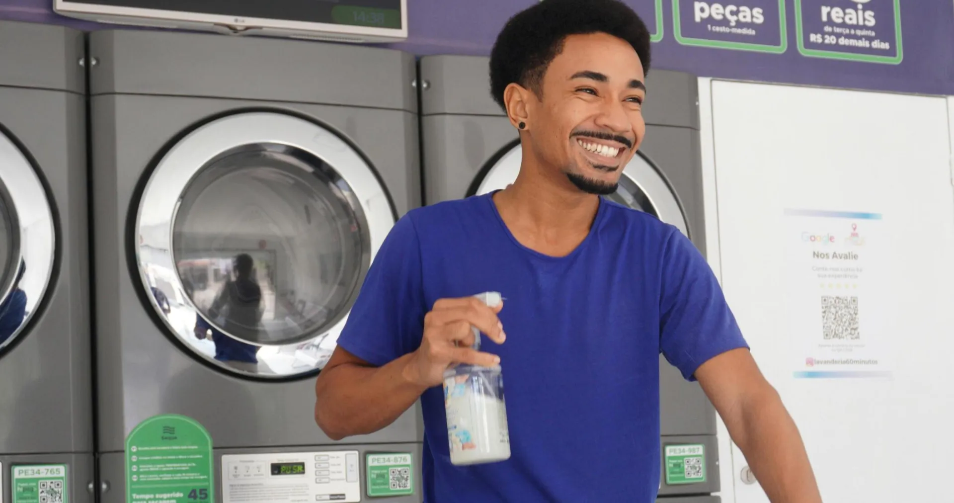 Smiling man folding clothes in a laundromat in Pernambuco, Brazil.