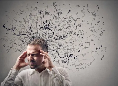 A worried businessman in corporate attire handling stress at his workspace.