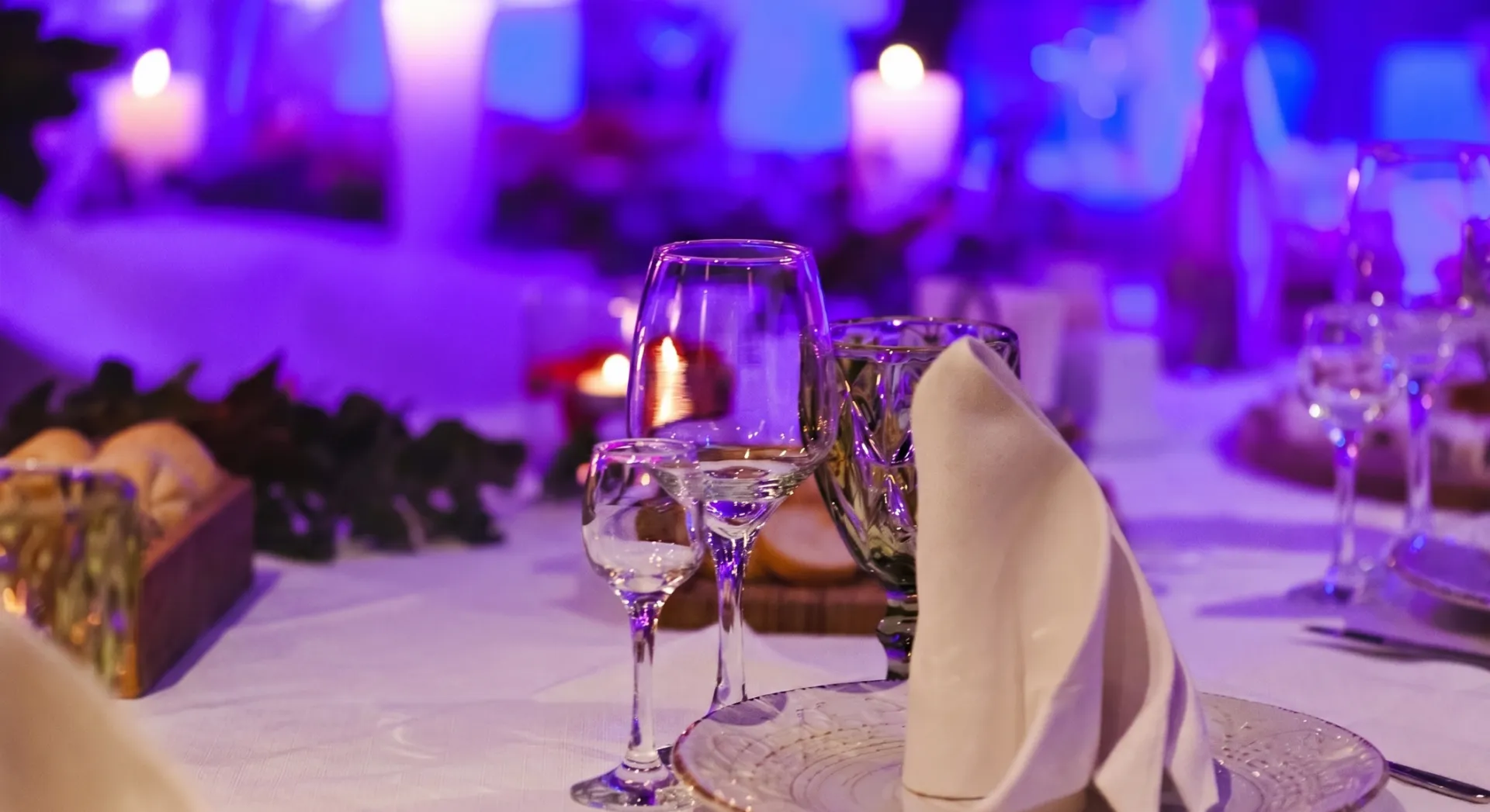 Sophisticated table setting with sushi platter, candlelights, and elegant glassware, perfect for fine dining ambiance.