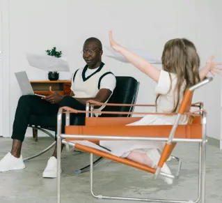 Father and daughter enjoying time together with a laptop in the living room.
