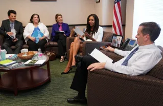 Stressed businessman overwhelmed by paperwork in office environment, demonstrating burnout.